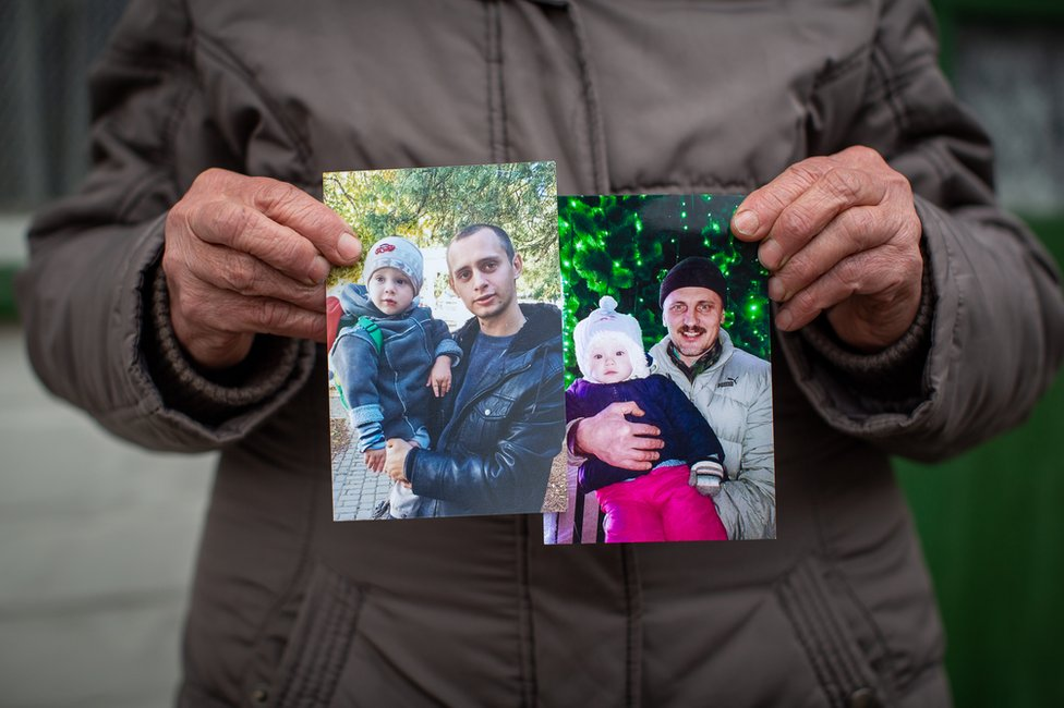 Nadia Holumenkov holds pictures of her grandson Nikita and son Oleksandr