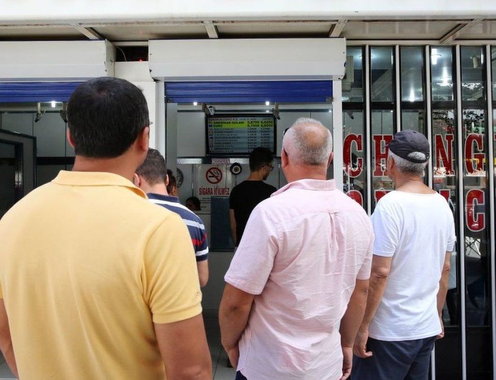 Turks in Ankara examine the fluctuating exchange rate at a currency exchange shop
