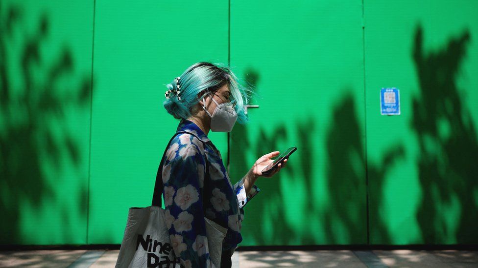 A woman, wearing a face mask following the coronavirus disease outbreak, walks past a construction site in Shanghai, China 1 July, 2022.