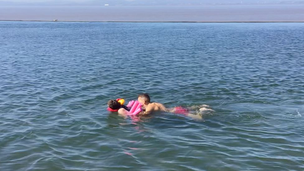 Two people swimming in a lake