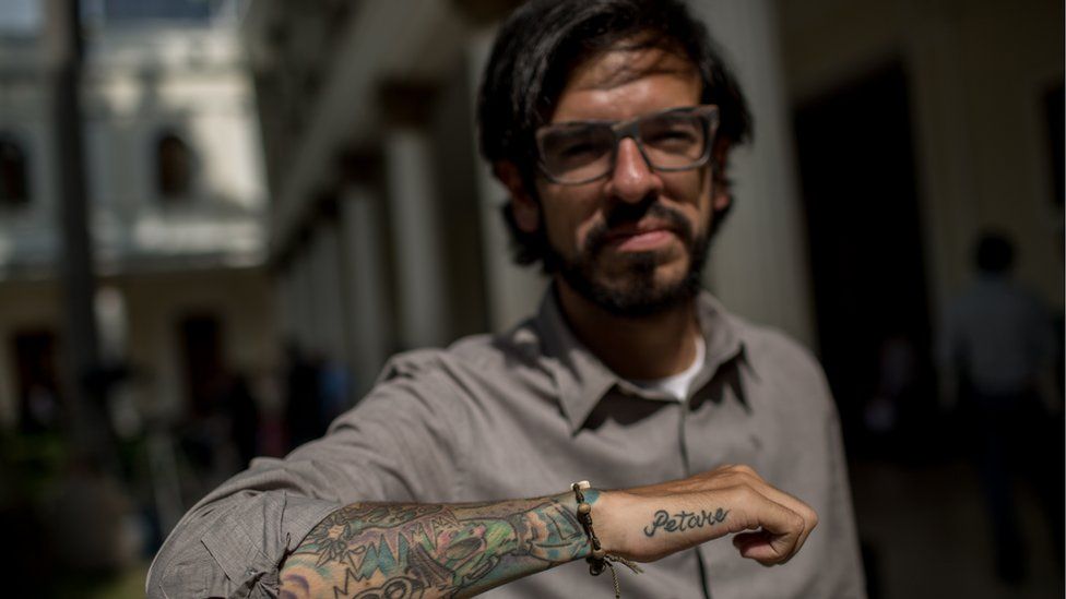 Lawmaker Miguel Pizarro shows of his tattoo reading "Petare"