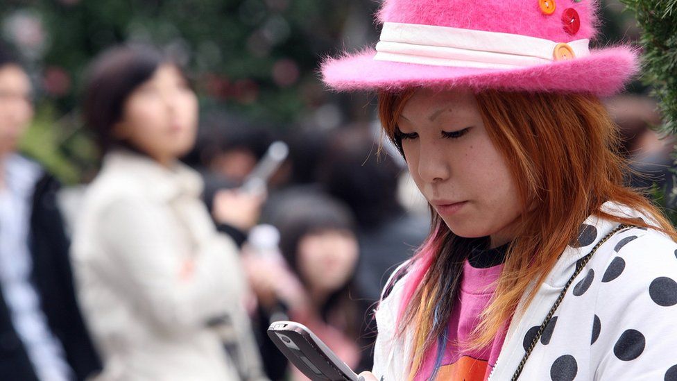 A Japanese woman uses a mobile phone on March 24, 2006 in Tokyo, Japan.
