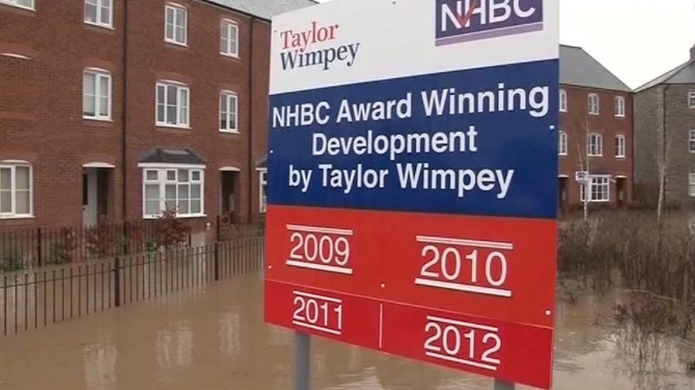 Taylor-Wimpey sign at flooded Glasdir estate in Ruthin, Denbighshire, November 2012