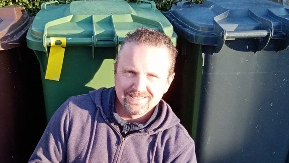 Dave Clark in front of some bins