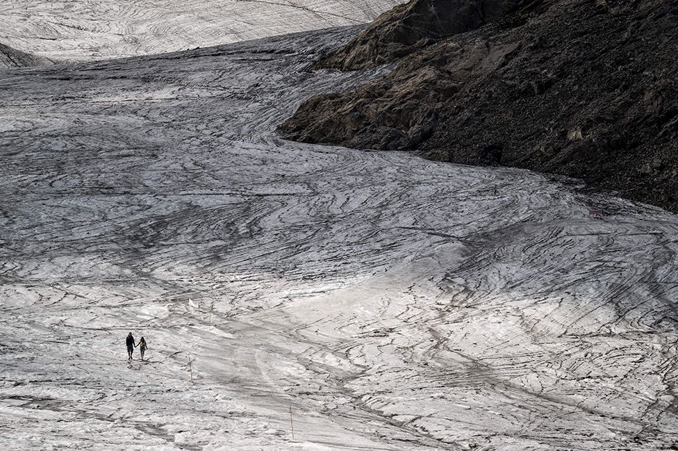 2022 оны 8-р сарын 6-ны өдөр Швейцарийн Лес Диаблеретс тосгоны дээгүүр хайлж буй Цанфлерон мөсөн гол дээр хосууд гар барьж байна