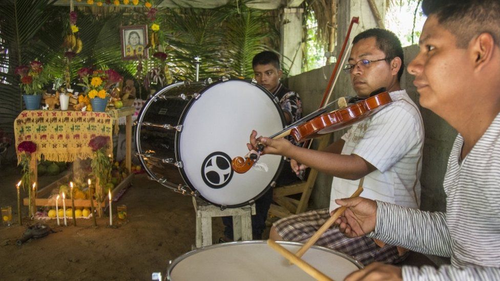 Коренные жители играют музыку у алтаря, делая подношения в Сан-Матео-дель-Мар, штат Оахака