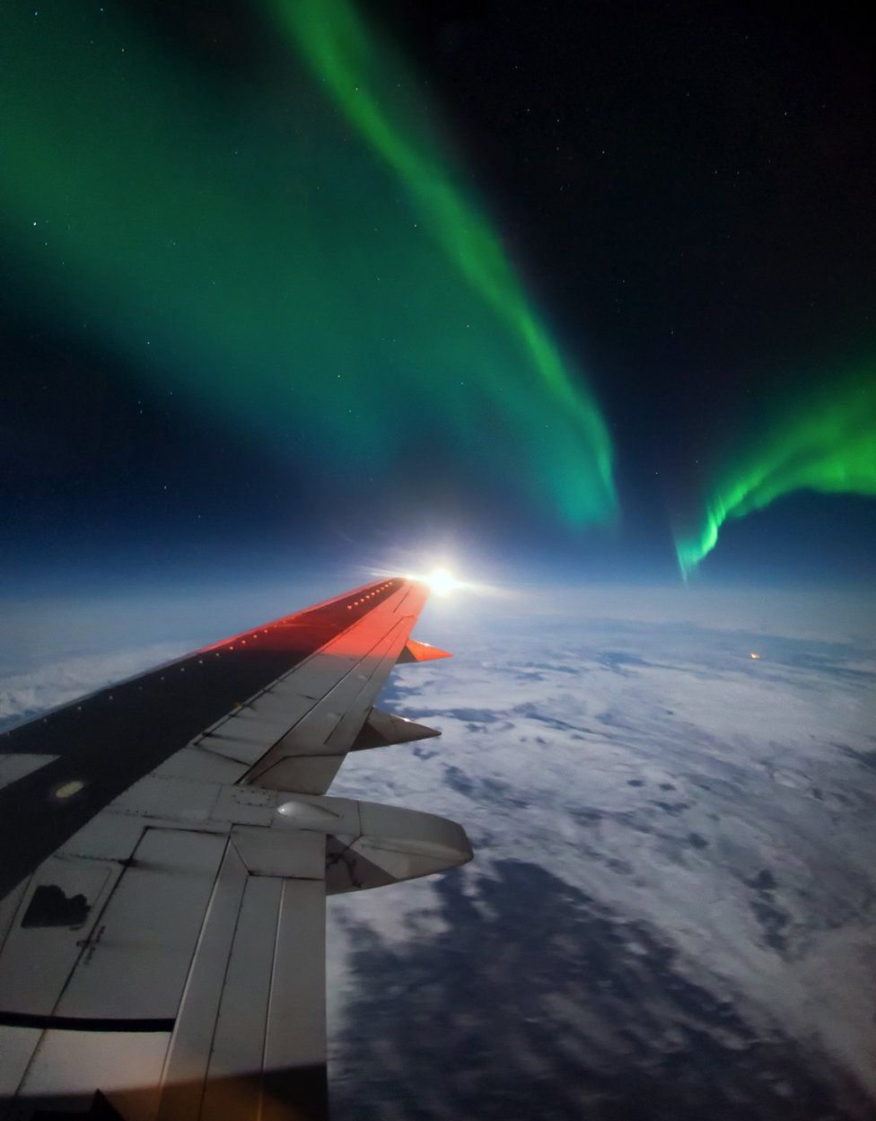 Northern lights and wing of the plane
