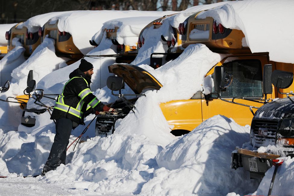 A man tries to start the engine of a school bus in Scarborough, Canada