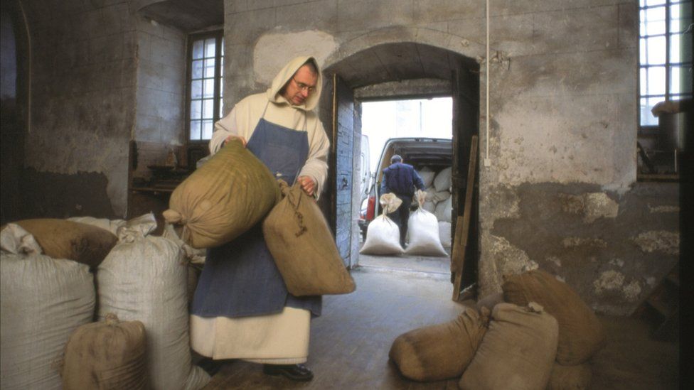 A monk carries plain sacks of secret plant formula