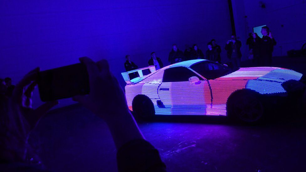 A Toyota Supra car covered in neon lights
