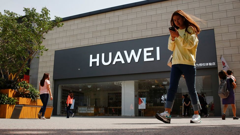 File photo of a person walking past a Huawei shop in Beijing