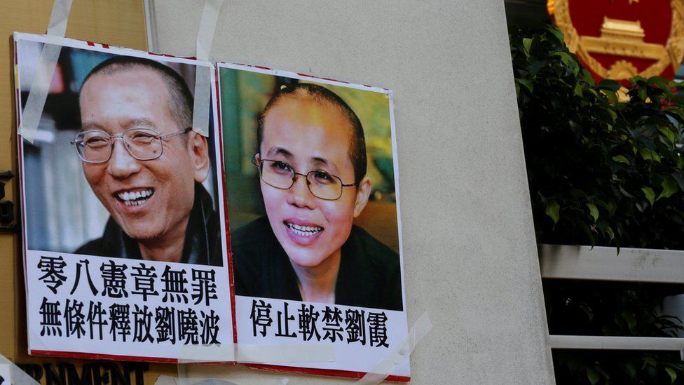 Photos of Chinese Nobel rights activist Liu Xiaobo (L) and wife Liu Xia are left by protesters outside China"s Liaison Office in Hong Kong, China June 27, 2017