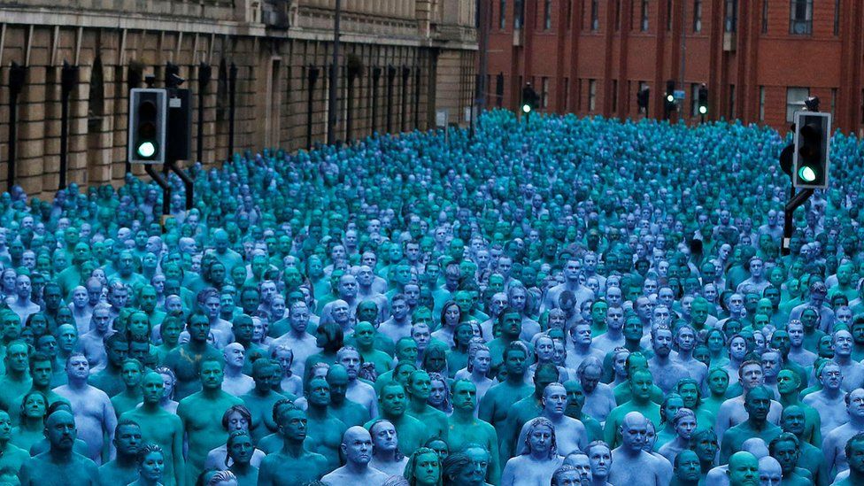 People nude and painted blue standing in Alfred Guilder Street