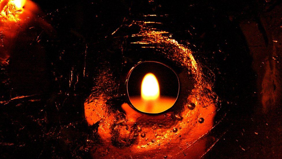 A candle seen through a hole in a sheet of ice