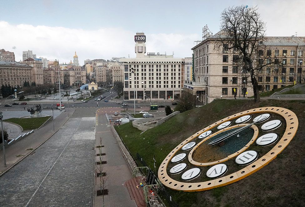 A clock showing the time at noon is seen near almost empty streets at Maidan Nezalezhnosti (Independence Square) in Kiev, Ukraine