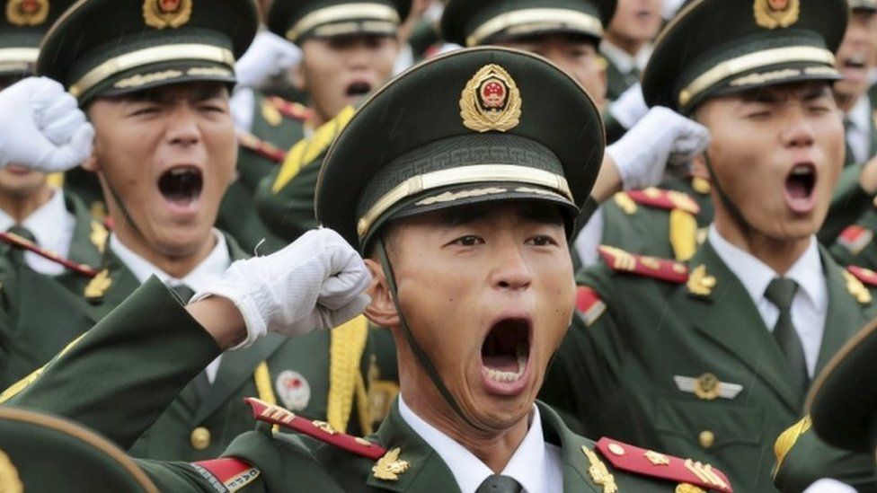 Paramilitary policemen and members of a gun salute team shout slogans at an oath-taking ceremony for the upcoming military parade to mark the 70th anniversary of the end of the World War Two, at a military base in Beijing, China, 1 September 2015