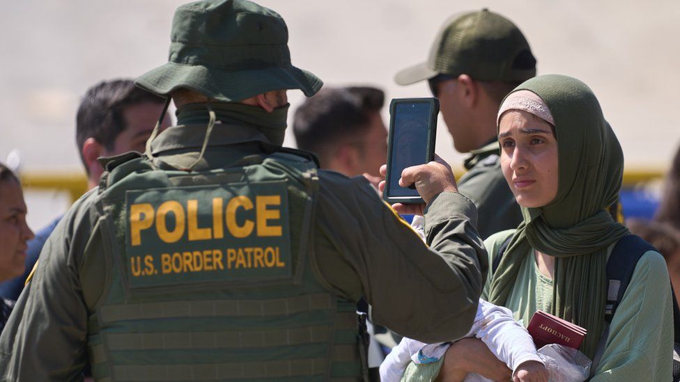 A woman has her photo taken during processing by US Border Patrol