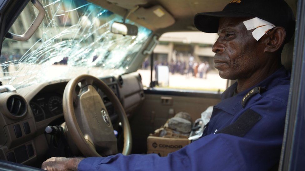 A wounded policeman, Nsonso Lenga Lambert, sits in a police vehicle that was damaged when two groups of Muslims clashed outside Martyrs' Stadium in Kinshasa, Democratic Republic of Congo - 13 May 2021.