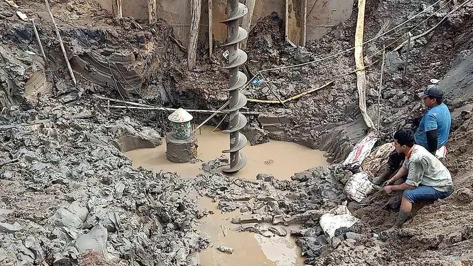 Rescuers are using a 19-metre-long metal pipe to loosen and remove mud around the pillar
