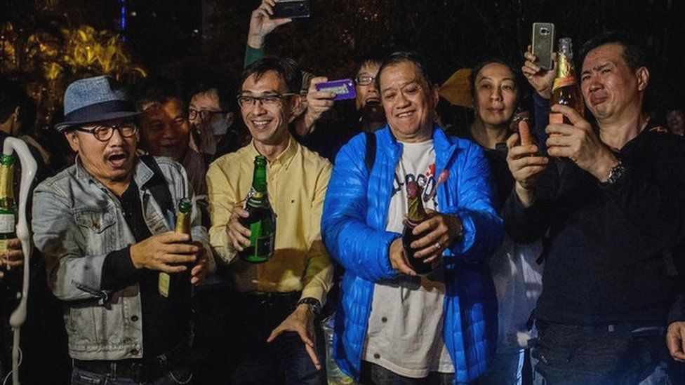 Pro-democracy protesters open champagne bottles to the news that unpopular chief executive Leung Chun-Ying said he would not run for office again in the March vote, during a rally outside his residence in Hong Kong on December 11, 2016,