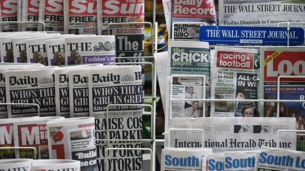 Newspapers displayed on a stand