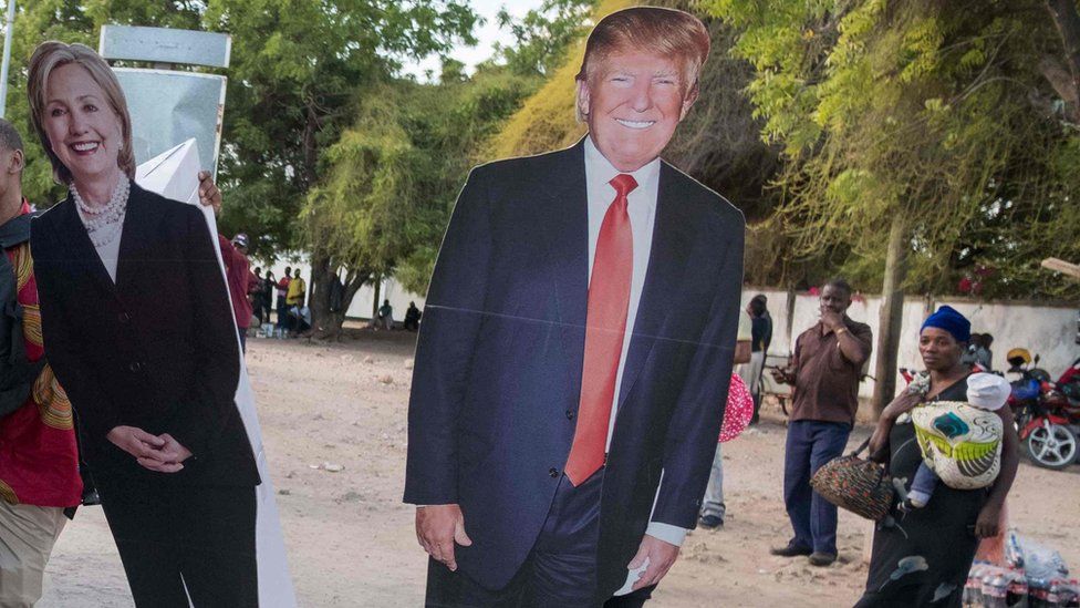 Cut outs of Hillary Clinton and Donald Trump are loaded onto a bus in Dar es Salaam, Tanzania on 7 November 2016