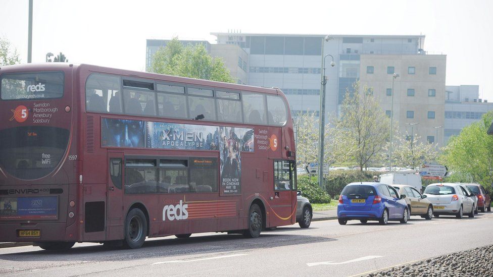 A red bus driving along a road