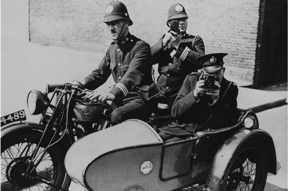 Traffic Policemen With Their Cameras To Photograph Road Accidents, In London