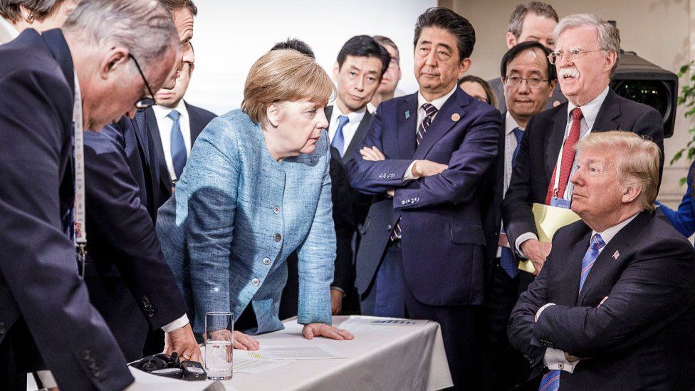 In this photo provided by the German Government Press Office (BPA), German Chancellor Angela Merkel deliberates with US president Donald Trump on the sidelines of the official agenda on the second day of the G7 summit on June 9, 2018 in Charlevoix, Canada, looked on by other leaders.