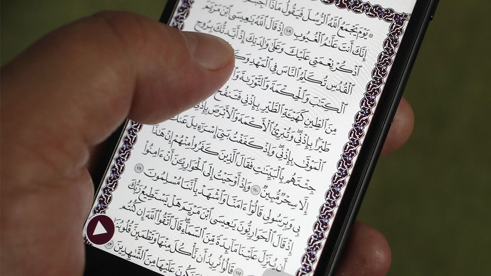Someone reading the Koran on a smartphone