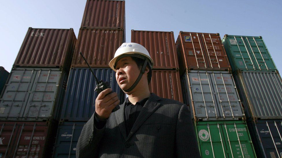 A worker monitors the loading of shipping containers in Hubei province in China
