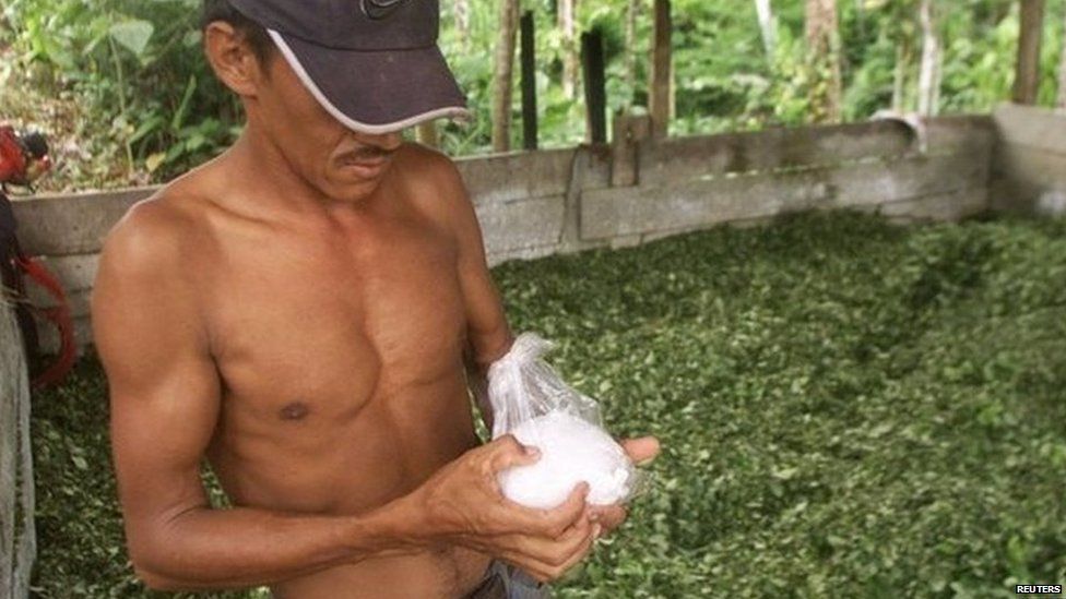 A Colombian peasant holds a bag of coca paste at a makeshift drug lab in Putumayo on 30 January, 2003