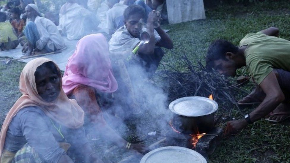 Rohingya refugees prepare meals in a school field after entering into Tuangiri, Teknaf, Bangladesh (12 September 2017)