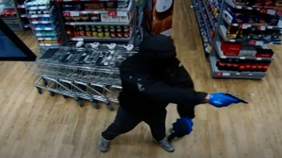 Mark Hamlet threatening a shop keeper with a gun