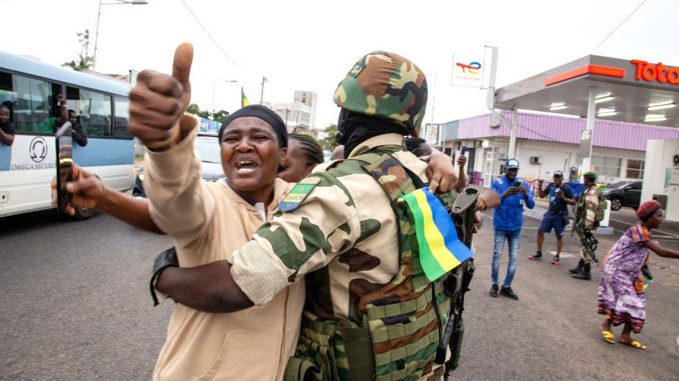 A joyful Gabonese woman embracing a soldier of the Republican Guard