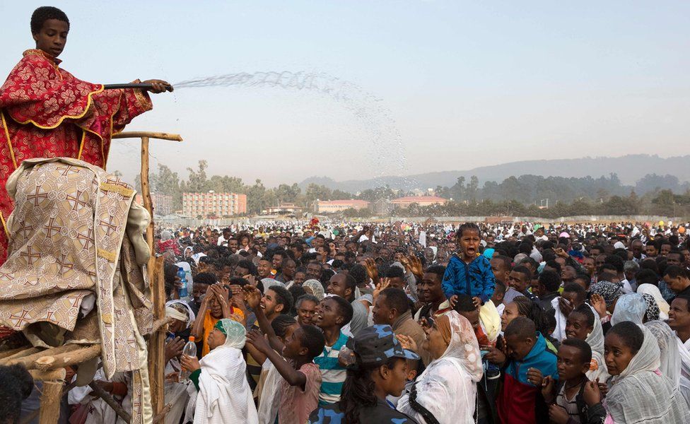 A clergy boy sprays blessed water onto patrons of the Ethiopian Orthodox church during the Timket, an Epiphany festival, in Addis Ababa, on January 19, 2018.