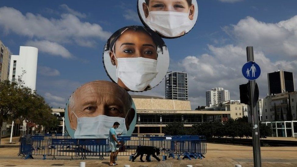 A sculpture decorated with images of people wearing face masks is seen at Habima Square, Tel Aviv, Israel (24 September 2020)
