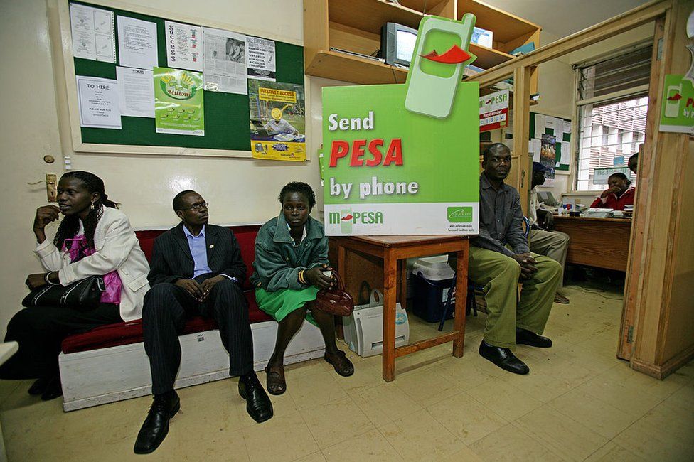 Customers wait in the office of an M-Pesa financial company office in Bungoma, Kenya