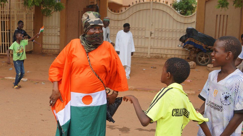 Coup supporters wave flags during the protest against a possible military intervention by the Economic Community of West African States (Ecowas) bloc and sanctions in Niamey, Niger on 20 August 2023.