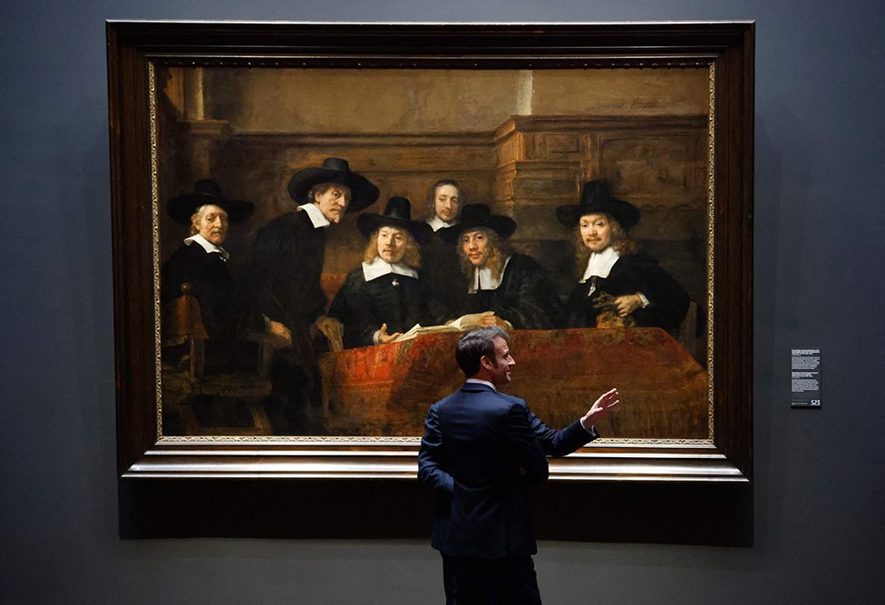 France's President Emmanuel Macron stands in front of the painting Syndics of the Drapers' Guild by Rembrandt during a visit to the Rijskmuseum in Amsterdam, the Netherlands, on 12 April 2023.
