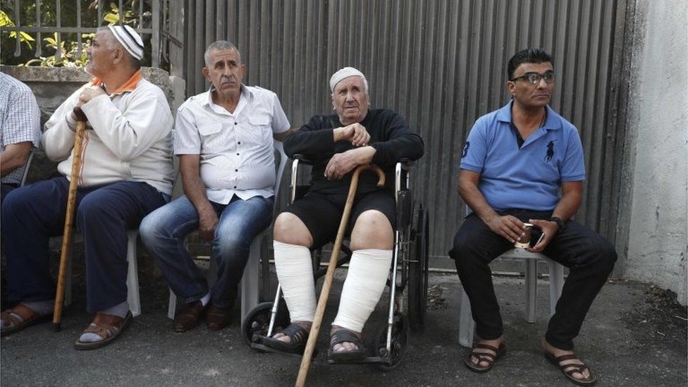 Ayoub Shamasneh (2nd right) and unidentified others outside the home in Sheikh Jarrah