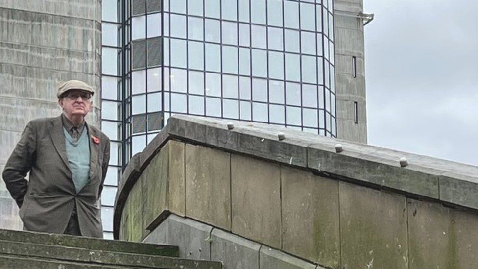 Man standing on top of the stairs observing the silence in Swansea