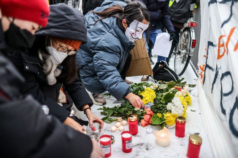 A demonstrator lights a candle at an onsite makeshift memorial, during a protest in front of the Chinese Embassy in solidarity with protesters in China on December 3, 2022 in Berlin, Germany.