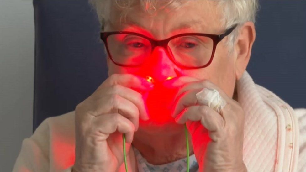 A red light being shone into a patient's nasal cavities