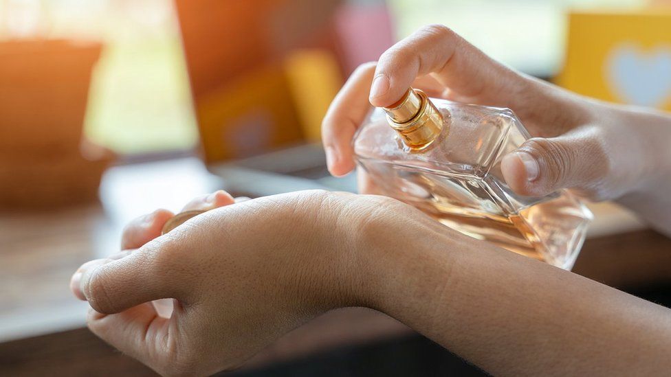 A woman spraying perfume on her wrist