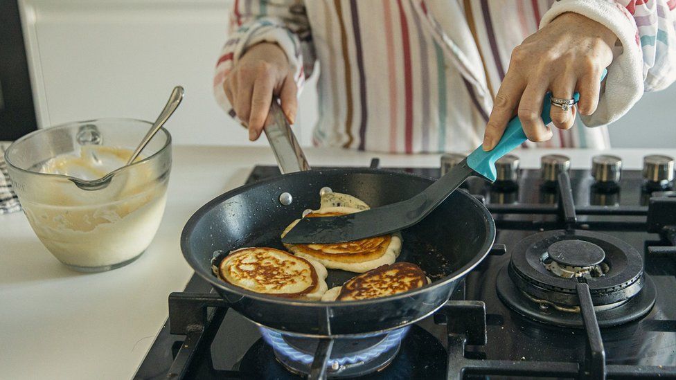 Person cooking on a gas hob