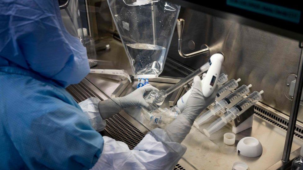 Employees in cleanroom suits test the procedures for the manufacturing of Covid-19 vaccines