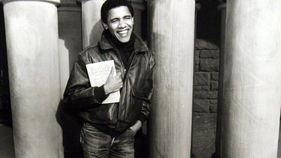 Obama as a student of Harvard Law School, where he became the first black president of the Harvard Law Review, of which he is holding a copy.