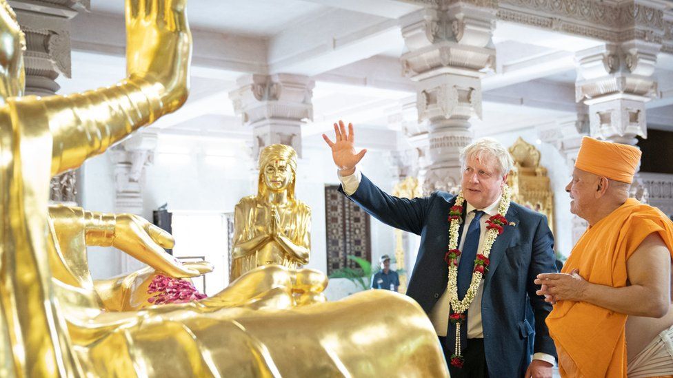 Prime Minister Boris Johnson talks to a sadhu as he visits the Swaminarayan Akshardham temple in Gandhinagar, Ahmedabad, as part of his two day trip to India.