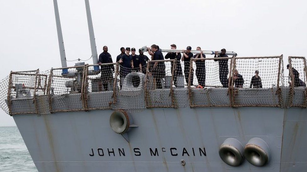 Personnel work on the US Navy guided-missile destroyer USS John S McCain after a collision in Singapore.